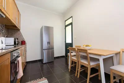 a kitchen with a table and a stainless steel refrigerator at Casa da Jackie by Rent-a-key in Funchal