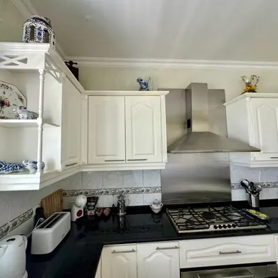 a kitchen with white cabinets and a stove top oven at Casa Neves in Arco da Calheta