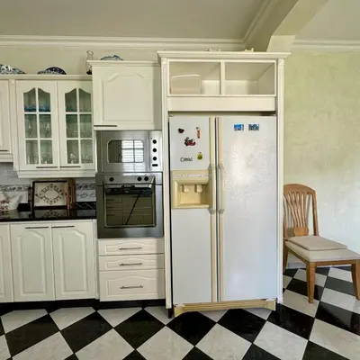 a kitchen with white cabinets and a refrigerator at Casa Neves in Arco da Calheta