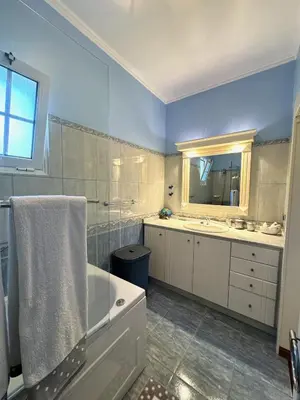 a bathroom with a tub and a sink and a mirror at Casa Neves in Arco da Calheta