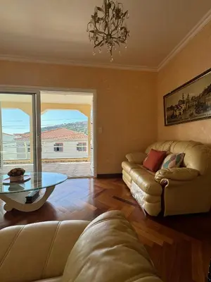 a living room with a couch and a table at Casa Neves in Arco da Calheta