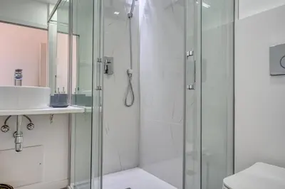 a bathroom with a glass shower and a sink at Maranta House, a Home in Madeira in Funchal