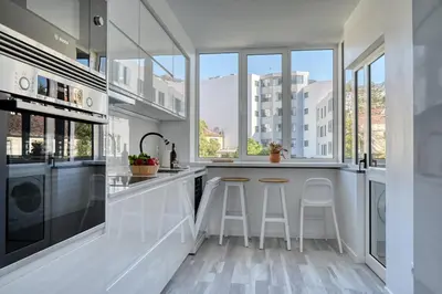 a kitchen with white counters and large windows at Maranta House, a Home in Madeira in Funchal
