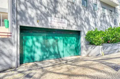 a green garage door on the side of a building at Maranta House, a Home in Madeira in Funchal
