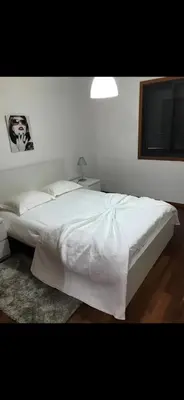 a bedroom with a large white bed with a window at O lagar in Câmara de Lobos