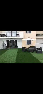 a building with a green yard with chairs on it at O lagar in Câmara de Lobos