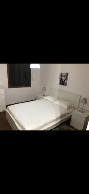 a bedroom with a large white bed and a tv at O lagar in Câmara de Lobos