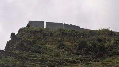 a building sitting on top of a hill at Casal São João Cottages in Fajã da Ovelha