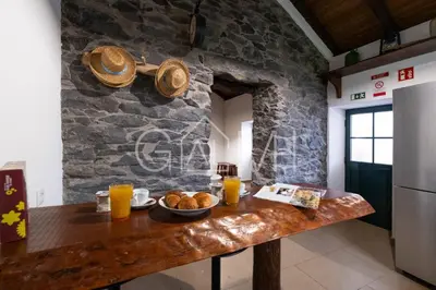 a kitchen with a table with bread and orange juice at Casa do Maurício by GALMI in Ponta do Pargo