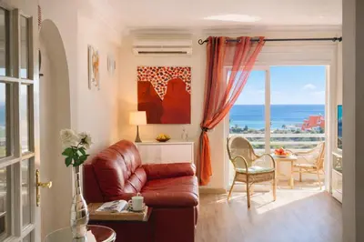 a living room with a couch and a view of the ocean at Dreamy Sea View Apartment with Access to Private Pool & Stunning Rooftop in Luz