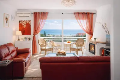 a living room with a couch and a table at Dreamy Sea View Apartment with Access to Private Pool & Stunning Rooftop in Luz