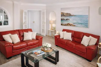 a living room with two red couches and a table at Dreamy Sea View Apartment with Access to Private Pool & Stunning Rooftop in Luz