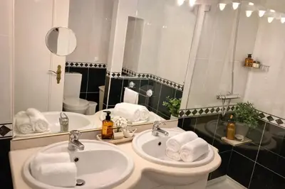 a bathroom with two sinks and a mirror at Dreamy Sea View Apartment with Access to Private Pool & Stunning Rooftop in Luz