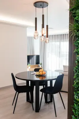 a dining room with a black table and chairs at Luxurious T2 Varandas Apartment XIII in Funchal