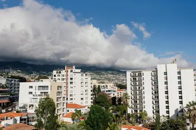 a city with white buildings and a cloudy sky at Luxurious T2 Varandas Apartment XIII in Funchal