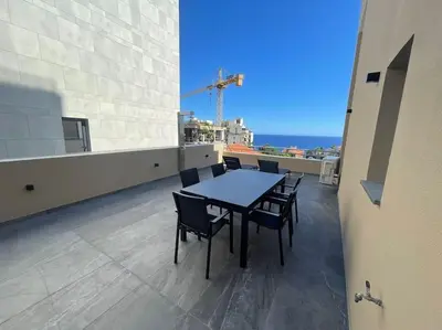 a table and chairs on the balcony of a building at Luxurious T2 Varandas Apartment XIII in Funchal