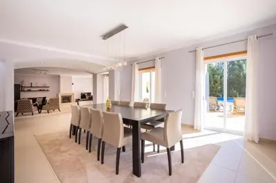 a dining room with a black table and chairs at Casa Amarela in Lagos