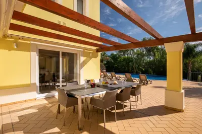 a patio with a table and chairs on a patio at Casa Amarela in Lagos