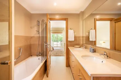 a bathroom with two sinks and a tub and a shower at Casa Amarela in Lagos