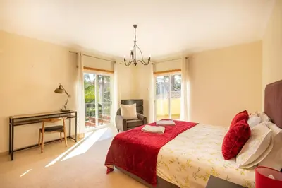 a bedroom with a bed and a desk in it at Casa Amarela in Lagos