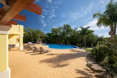 a patio with a swimming pool and lounge chairs at Casa Amarela in Lagos