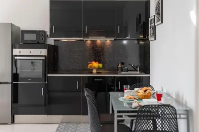 a kitchen with black cabinets and a table with fruit on it at Apartamento América II by An Island Apart in Funchal