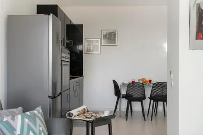 a kitchen with a refrigerator and a table with chairs at Apartamento América II by An Island Apart in Funchal