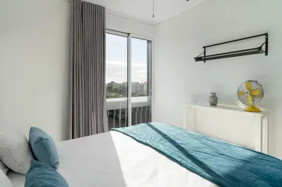 a bedroom with a bed and a large window at Apartamento América II by An Island Apart in Funchal