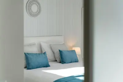 a bedroom with a bed with blue pillows at Apartamento América II by An Island Apart in Funchal