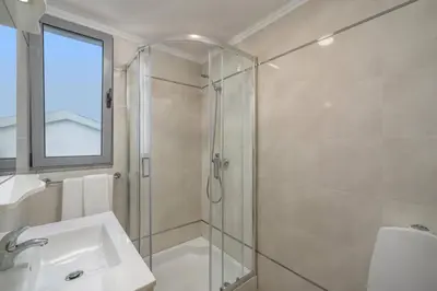 a bathroom with a glass shower and a sink at Villa Atlantic Sunset by Villa Plus in Funchal