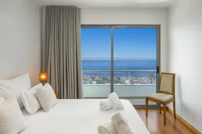 a hotel room with a bed and a large window at Villa Atlantic Sunset by Villa Plus in Funchal