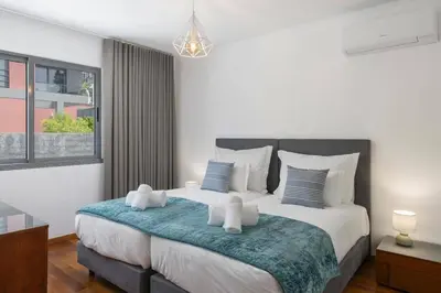 a bedroom with a large bed with a blue blanket at Villa Atlantic Sunrise by Villa Plus in Funchal