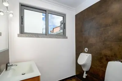 a bathroom with a toilet and a sink and a window at Villa Atlantic Sunrise by Villa Plus in Funchal