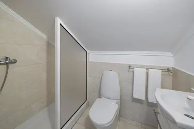 a white bathroom with a toilet and a sink at Villa Atlantic Sunrise by Villa Plus in Funchal