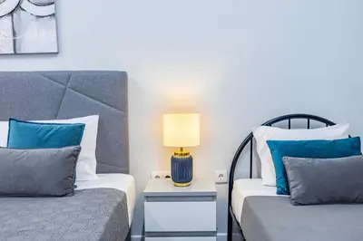 a bedroom with two beds and a lamp on a table at Magalhães AL by YOUR KEY MADEIRA in Machico