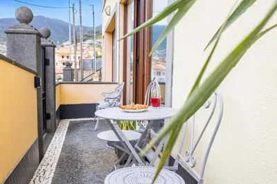 a table on a balcony with a bowl of food on it at Magalhães AL by YOUR KEY MADEIRA in Machico