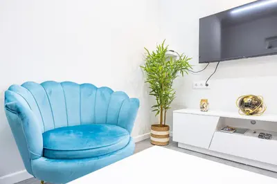 a blue chair in a living room with a tv at Magalhães AL by YOUR KEY MADEIRA in Machico