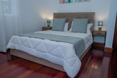a bedroom with a large white bed with blue pillows at Countesses Villa in Câmara de Lobos