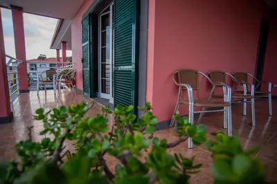 a balcony with chairs and tables on a building at Countesses Villa in Câmara de Lobos