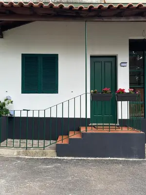 a house with a green door and two windows at Habitación santo antonio in Estrela