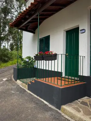 a house with a green door and a balcony with flowers at Habitación santo antonio in Estrela