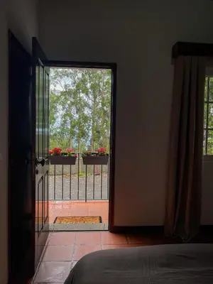 an open door to a balcony with flowers on a fence at Habitación santo antonio in Estrela
