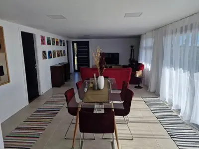 a living room with a table and red chairs at Casa Vieira in Fajã da Ovelha