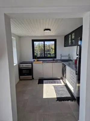 a large kitchen with a sink and a stove at Casa Vieira in Fajã da Ovelha
