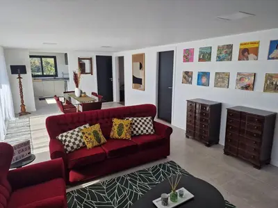 a living room with a red couch and a table at Casa Vieira in Fajã da Ovelha