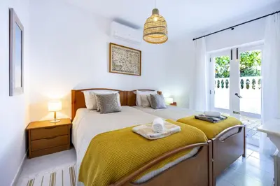 a white bedroom with a large bed and a window at CoolHouses Algarve Luz,3 bed townhouse, lovely sea view, walking distance to beach, Casa 24 LBC in Luz