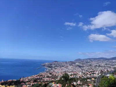a view of a city with the sun setting over the ocean at Villa São João in Funchal