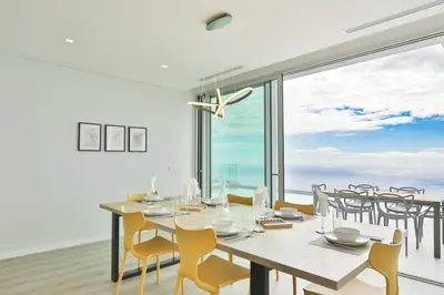 a dining room with a table and chairs and a large window at Villa Noelia Ocean View in Prazeres
