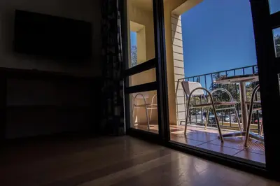 a bedroom with a bed and a living room at Apartamentos Turisticos Avenue Park in Funchal