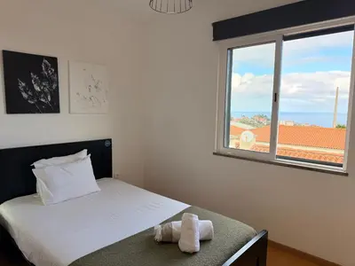 a bedroom with a bed with a large window at Zezita's Place in São Jorge